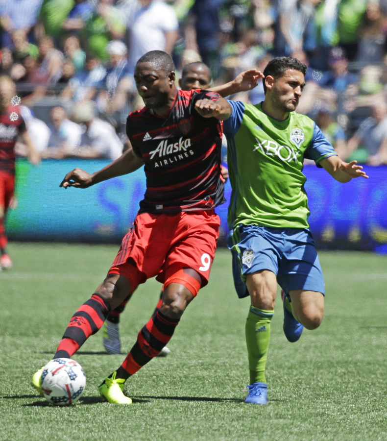 Portland Timbers forward Fanendo Adi, left, is challenged by Seattle Sounders midfielder Cristian Roldan, right, in the first half of an MLS soccer match, Saturday, May 27, 2017, in Seattle. (AP Photo/Ted S.
