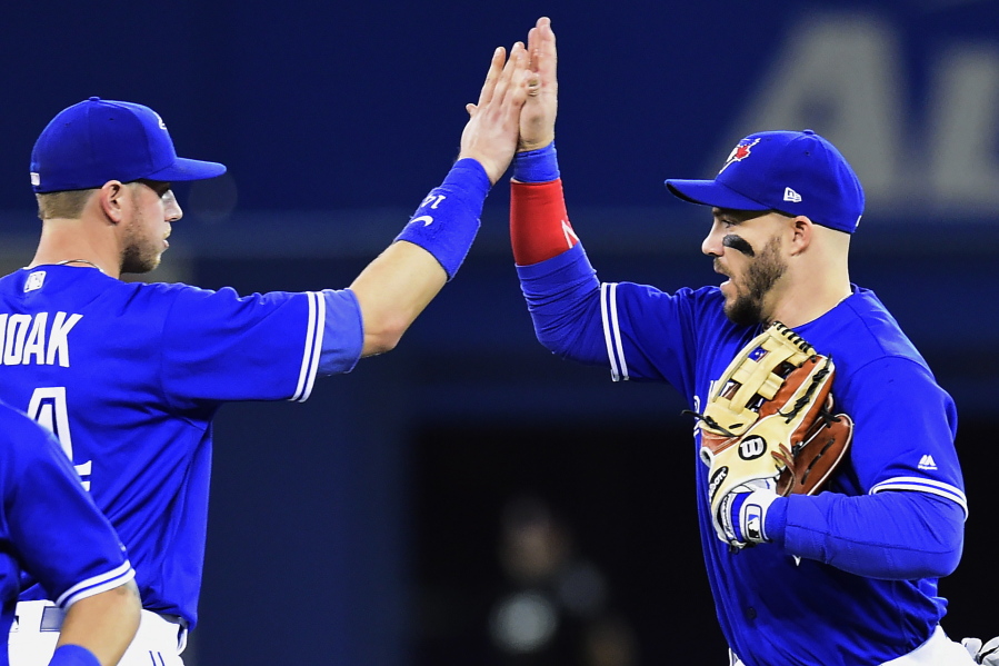 Toronto Blue Jays' Justin Smoak, left, and Steve Pearce celebrate after the Blue Jays defeated the Seattle Mariners 7-2 in a baseball game in Toronto on Thursday, May 11, 2017.