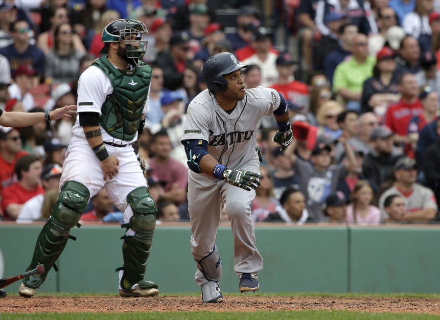 Seattle Mariners' Robinson Cano, right, watches the flight of his two-run home run as Boston Red Sox's Sandy Leon, left, looks on in the ninth inning of a baseball game, Sunday, May 28, 2017, in Boston. The Mariners shut out the Red Sox 5-0.