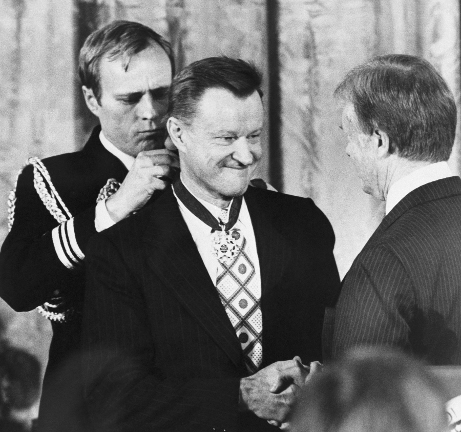 FILE - In this Jan. 17, 1981 file photo, President Jimmy Carter shakes hands with his national security adviser, Zbigniew Brzezinski, as he presents Brzezinski with the Medal of Freedom at a White House ceremony in Washington. Brzezinski, the national security adviser to President Carter, has died at age 89. His death was announced on social media Friday night, May 26, 2017, by his daughter, MSNBC host Mika Brzezinski.