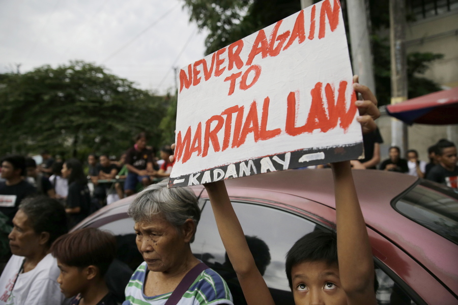 A boy raises a sign opposing the recent declaration of martial law in Mindanao by Philippine President Rodrigo Duterte during a rally Friday outside the presidential palace in Manila, Philippines.