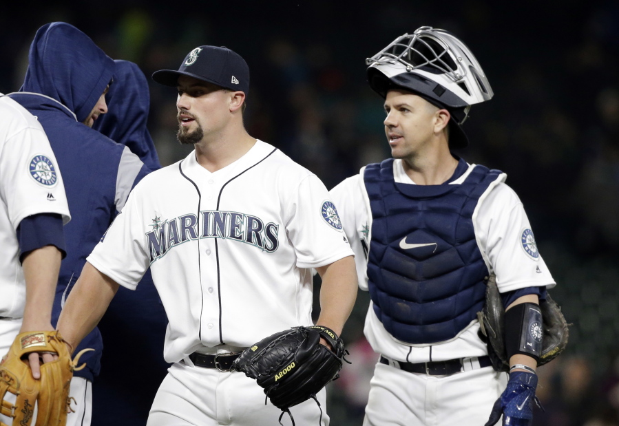 Seattle Mariners closing pitcher Dan Altavilla, left, and catcher Tuffy Gosewisch share congratulations with teammates after the team beat the Texas Rangers in a baseball game Saturday, May 6, 2017, in Seattle. The Mariners won 8-2.