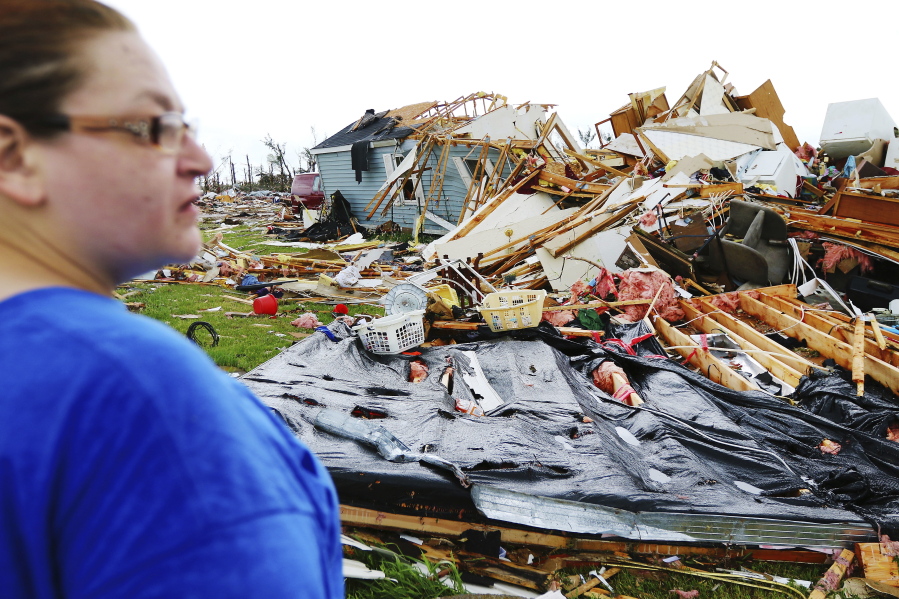 Ann Rutledge looks at the damage to her mobile home at the Prairie Lake Estates mobile home park in Barron County, Wednesday, May 17, 2017, in Chetek, Wis. Rutledge and her family had lived in that home for over 20 years. Residents of an Oklahoma subdivision and a Wisconsin trailer park that were leveled by deadly tornadoes sifted through what remained of their homes and possessions Wednesday, even as forecasters warned of another round of powerful storms on the horizon.