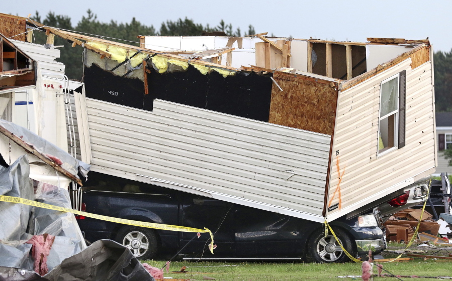 Part of a building sits on a vehicle after a tornado ripped through Prairie Lake Estates mobile home park Tuesday just north of Chetek, Wis.