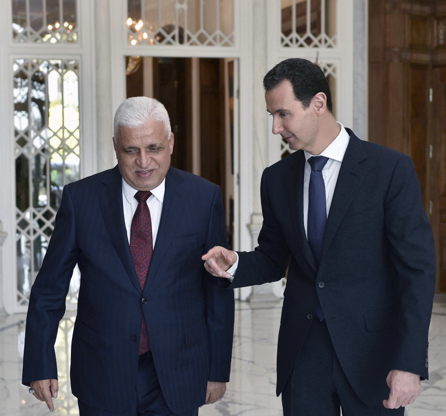 In this photo released by the Syrian official news agency SANA, Syrian President Bashar Assad, right, speaks with Iraq’s National Security Adviser Faleh al-Fayadth, in Damascus, Syria, on Thursday.