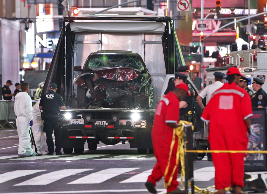The car driven by a man who steered his car onto a busy Times Square sidewalk, killing a teenager and injuring nearly two dozen others, is removed by police and investigators from the crime scene area on Thursday, May 18, 2017, in New York. The driver, a 26-year-old U.S. Navy veteran, told officers he was hearing voices and expected to die, two law enforcement officials said.