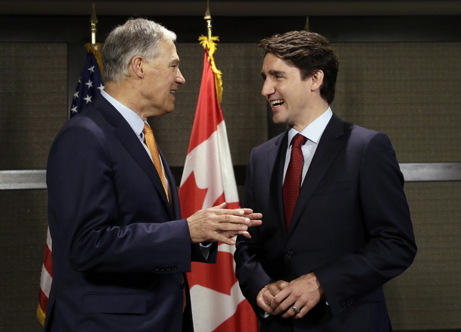 Canada Prime Minister Justin Trudeau, right, and Washington state Gov. Jay Inslee chat as they pose for photographers before a meeting Thursday in Seattle. The two were to discuss trade, regional economic development, and climate.