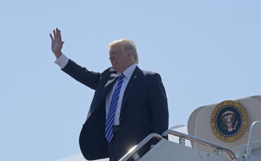 President Donald Trump waves as he walks off Air Force One at Groton-New London Airport in Groton, Conn., on Wednesday. Trump is giving the commencement address at the U.S. Coast Guard Academy.