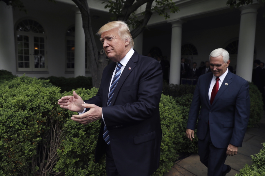 President Donald Trump claps as he arrives in the Rose Garden of the White House on May 4, followed by Vice President Mike Pence after the House pushed through a health care bill.