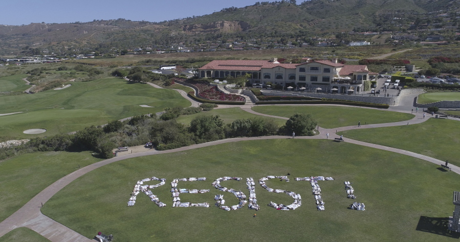 In this aerial photo released by Indivisible San Pedro protesters spell out the word “RESIST !”” on the Trump National Golf Los Angeles in Rancho Palos Verdes, Calif., on Saturday.