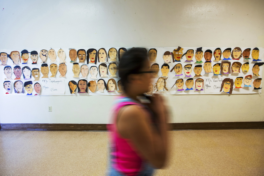 A poster of self-portraits hand-painted by students is displayed May 9 in a hallway at Hoover Elementary School in Yakima.