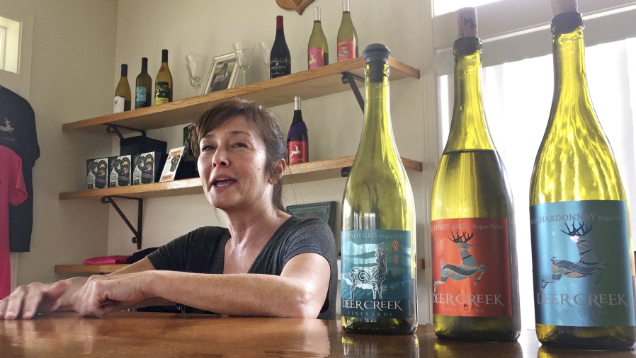 Vineyard owner Katherine Bryan laughs as she discusses the wines available for tasting at Deer Creek Vineyards in Selma, Ore. Bryan is one of a handful of vineyard owners and winemakers in this fertile corner of southwestern Oregon who are branching out into marijuana farming after the legalization of recreational weed in Oregon two years ago.