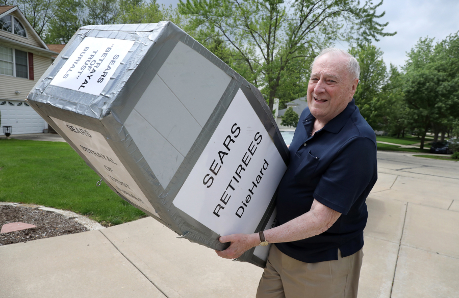 Sears retiree Leo McCormack, 79, holds a homemade replica coffin on May 25, 2017 outside his Naperville, Ill. home. McCormack, who retired in 1993, made the casket for a past protest against cuts to Sears retirement benefits.