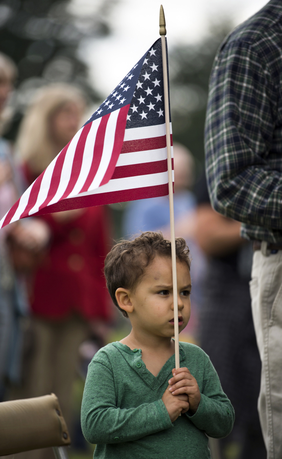 Manny Denver of Vancouver, 4, holds an American flag as he watches Fort Vancouver’s Flag Day celebration.