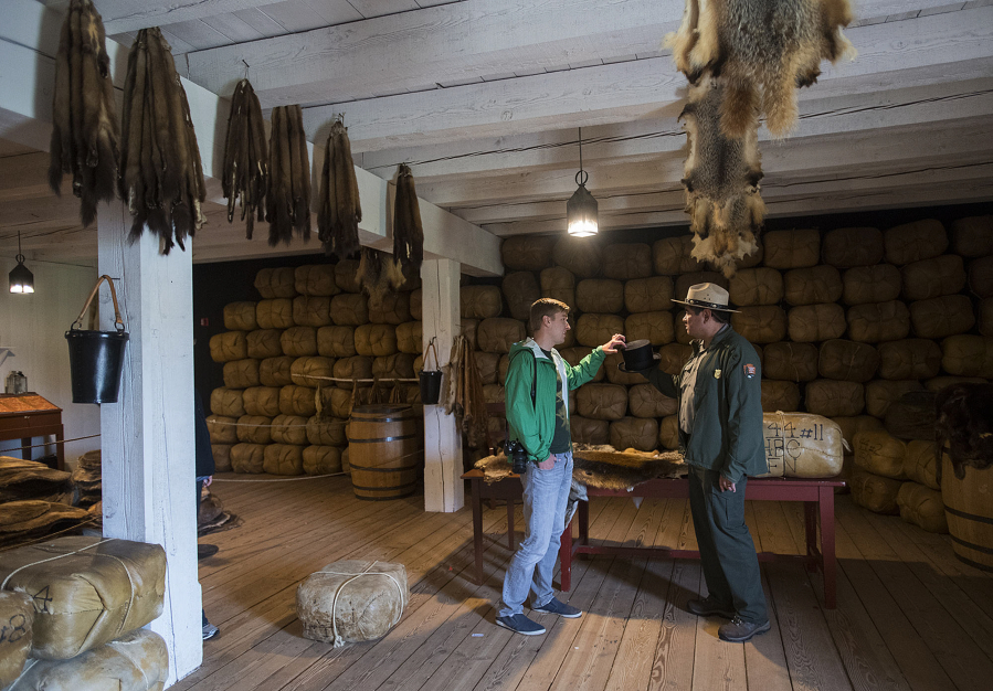 Mikah Meyer, left, 31, who is on a three-year road trip to visit all 417 national parks, and Ranger Bob Cromwell stop in the reconstructed fur store during Friday’s tour of Fort Vancouver National Historic Site.