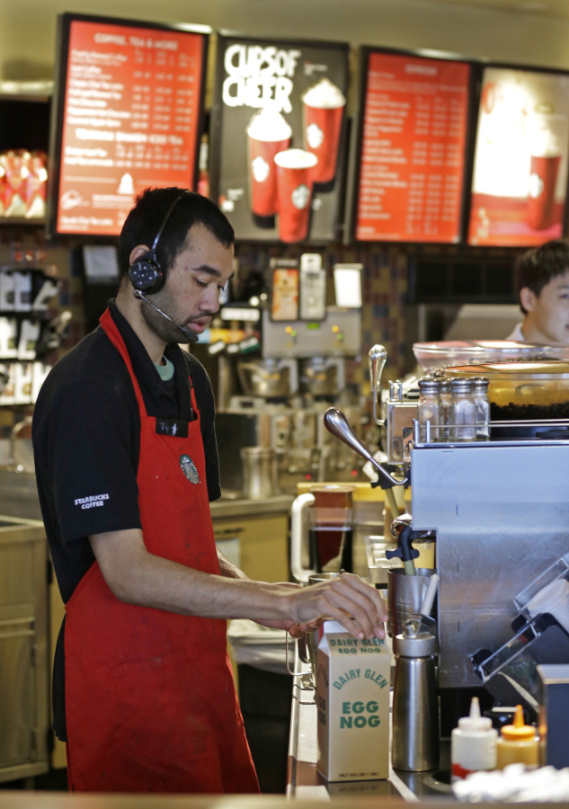 Barista Jay Rapp prepares an Eggnog Latte at a Starbucks store Nov. 24, 2014, in Seattle. Starbucks baristas are petitioning the company to change its parental leave policy to accommodate adoptive parents or spouses of birth mothers. Ted S.