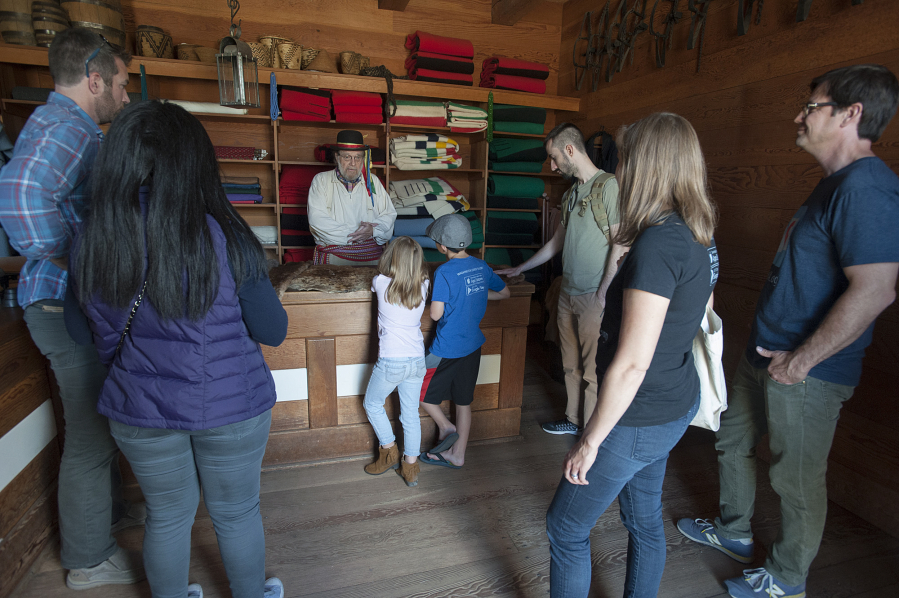 Volunteer Joseph Oleksiewicz, in the black hat, tells Ruby and Henry Fry, at the counter, about the fur trade at Fort Vancouver during their family’s visit in July 2016.
