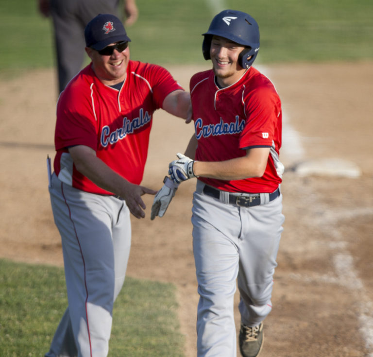 Vancouver Cardinals left fielder Garrett Wellman (24) is congratulated by head coach Ty Singleton after a two-run homer against the Federal Way Buzz.