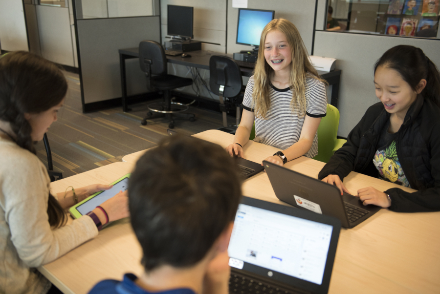 Odyssey Middle School seventh-graders Daisy Gooch, from left, Matthew Houlding, Lauren Mayer and Jace Morik work on presentation projects in class. The Camas School District adopted a new policy that limits the amount of homework teachers can assign students, with the idea that it will make classes more lively and discussion-based as students focus the act of learning instead of spend time finishing homework assignments.