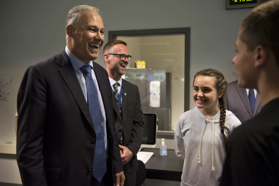 Gov. Jay Inslee, from left, talks with Odyssey Middle School Principal Aaron Smith and seventh-graders Jordan Jonason and Tai Beaulieu during a tour of the Camas campus.