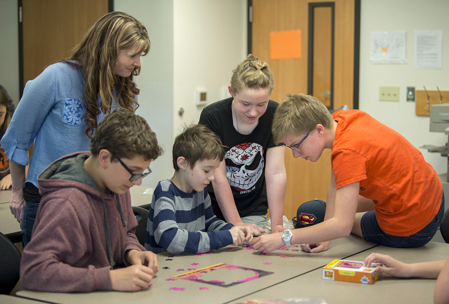 Prevention and intervention specialist Kari Koller, standing in blue, works with Prevention Club members Ray Miller, 13, from left, Gabe Slaton, 13, Natasha Young, 12, and Sydney Wheaton, 12, during a meeting of the Prevention Club at Chief Umtuch Middle School in Battle Ground on May 26.