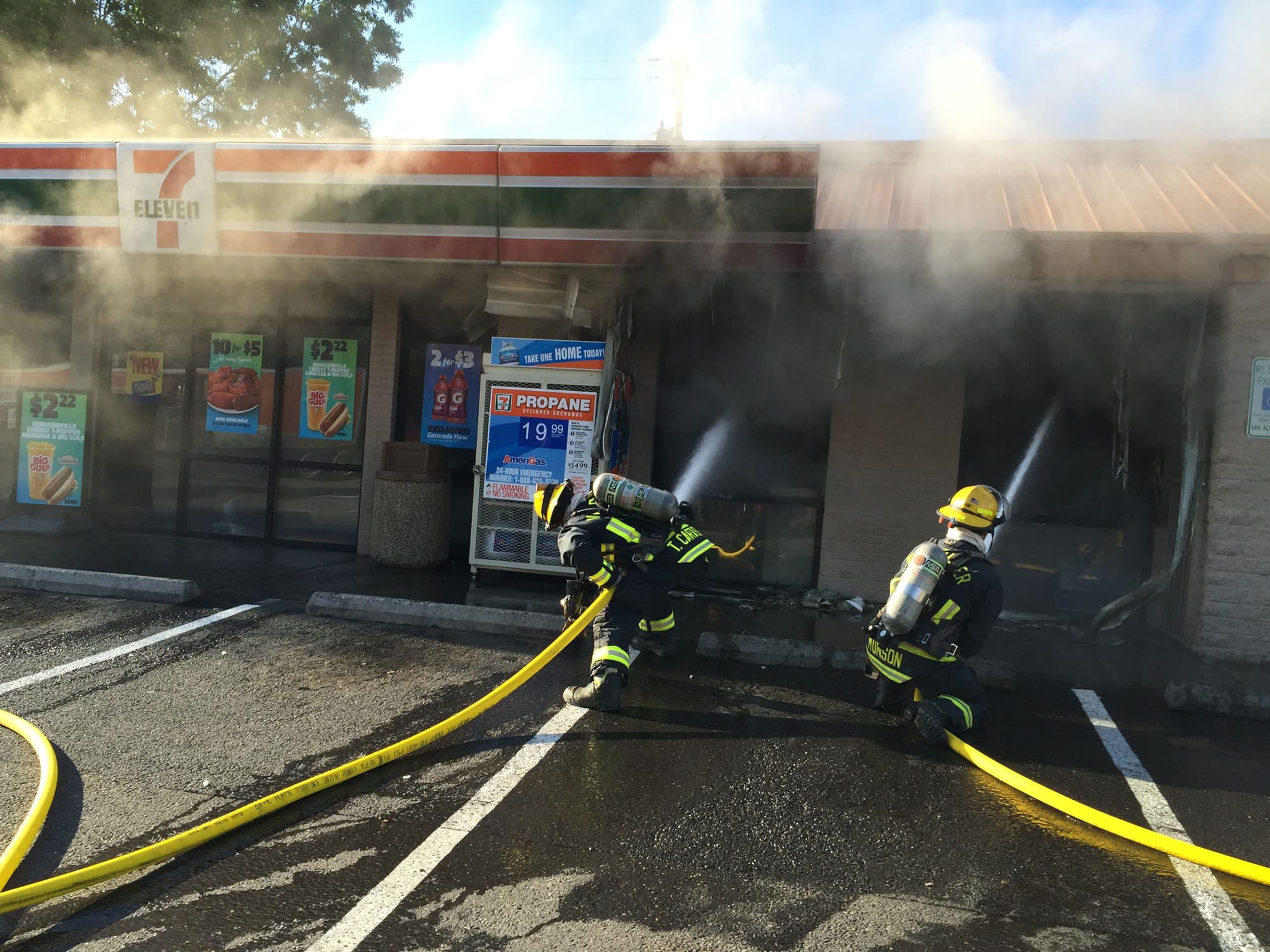 Firefighters work to douse the flames after a fire broke out in the the 7-Eleven at Main Street and West Fourth Plain Boulevard Wednesday evening.