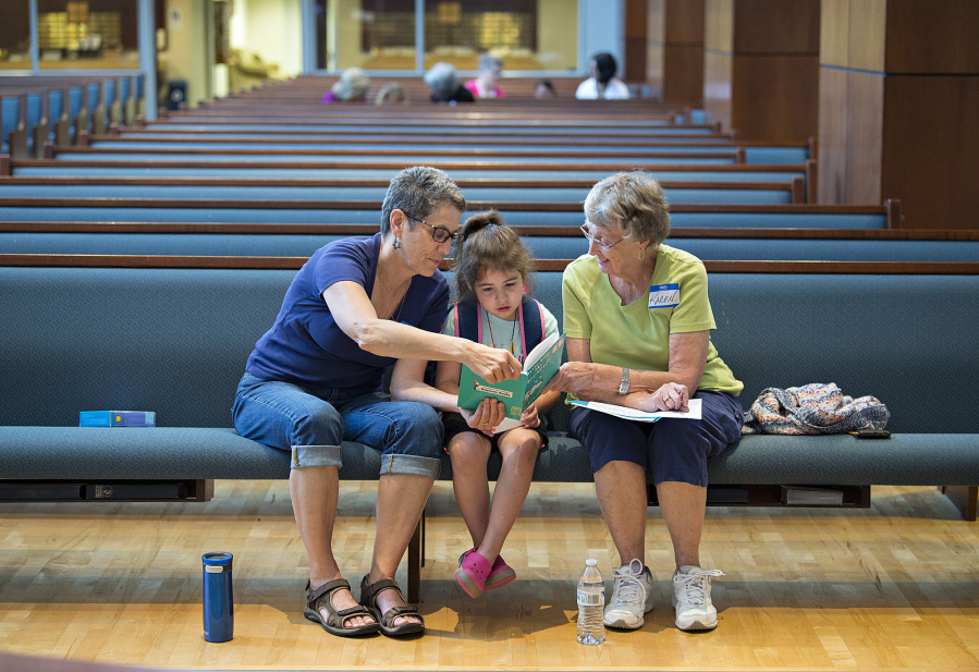 Volunteer Karen Beilsmith of Salmon Creek United Methodist Church, from left, reads to Mila Hughes, 6, with fellow volunteer and church member Karen West during Project Transformation at Vancouver First United Methodist Church on Thursday morning. The new summer day camp is designed to ease the summer learning loss children suffer over the summer away from school.