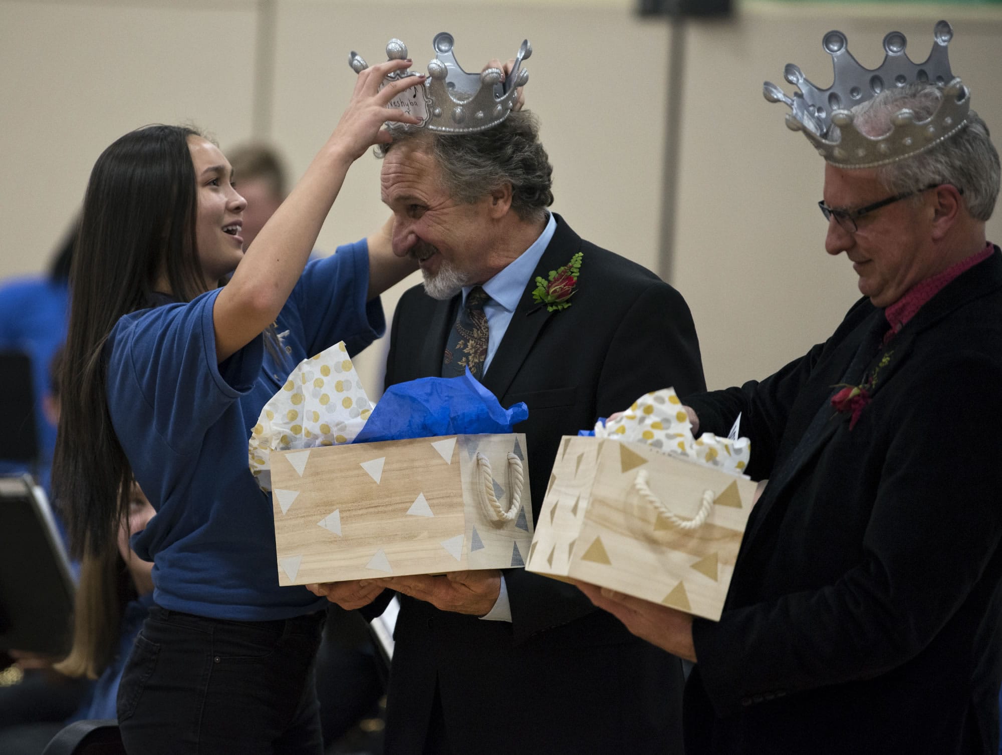 Wy’east Middle School eighth-grader Lillian Kates, from left, presents music teachers Mark Neshyba and Pete Boule with gifts from the eighth-grade class during the duo’s retirement celebration at the school on Tuesday. The eighth-grade class declared the teachers “Kings of Wy’east” in honor of their combined 56 years of teaching at the school. Both retire this year.