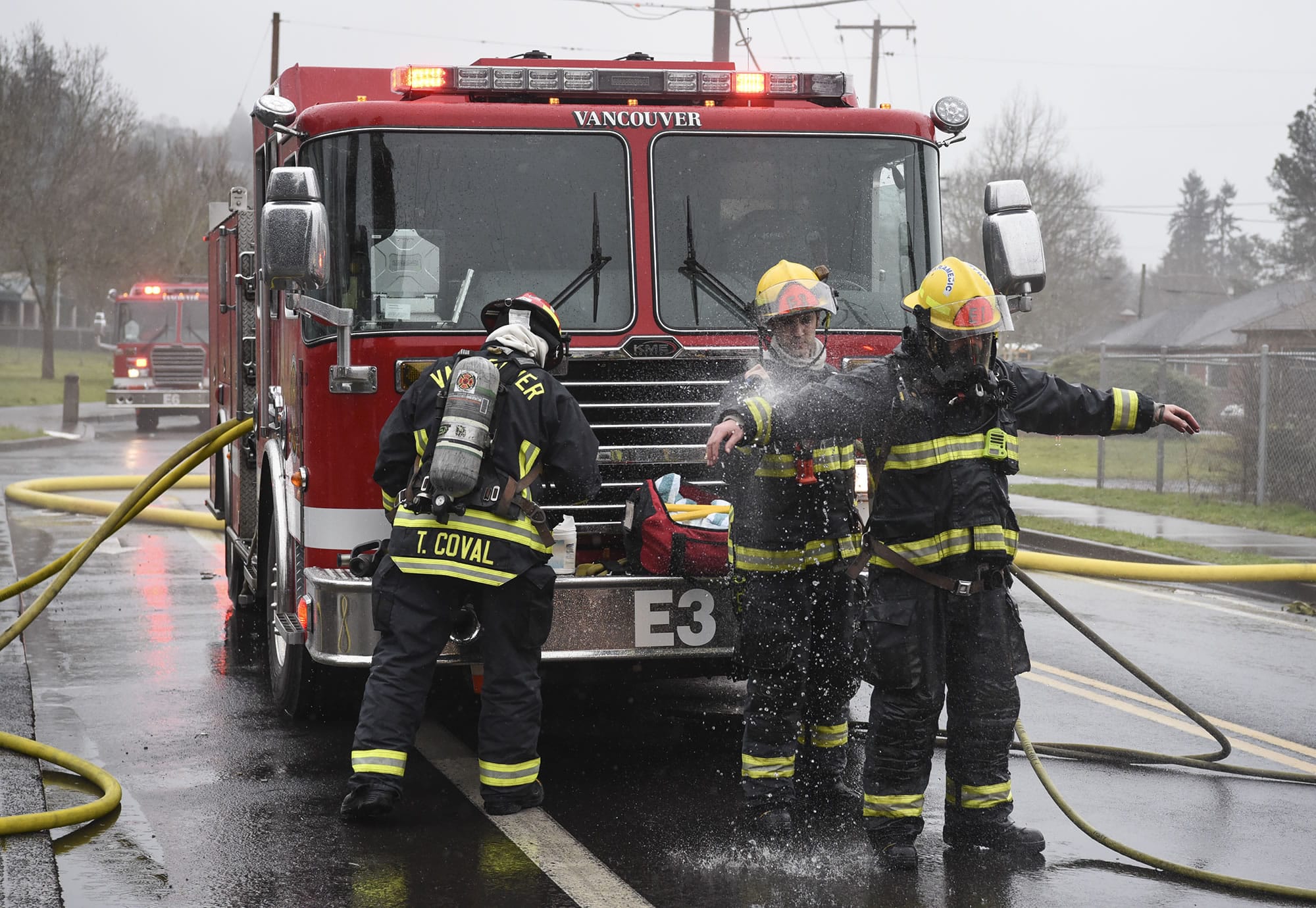 Members of the Vancouver Fire Department clean off after putting out a fire in March.
