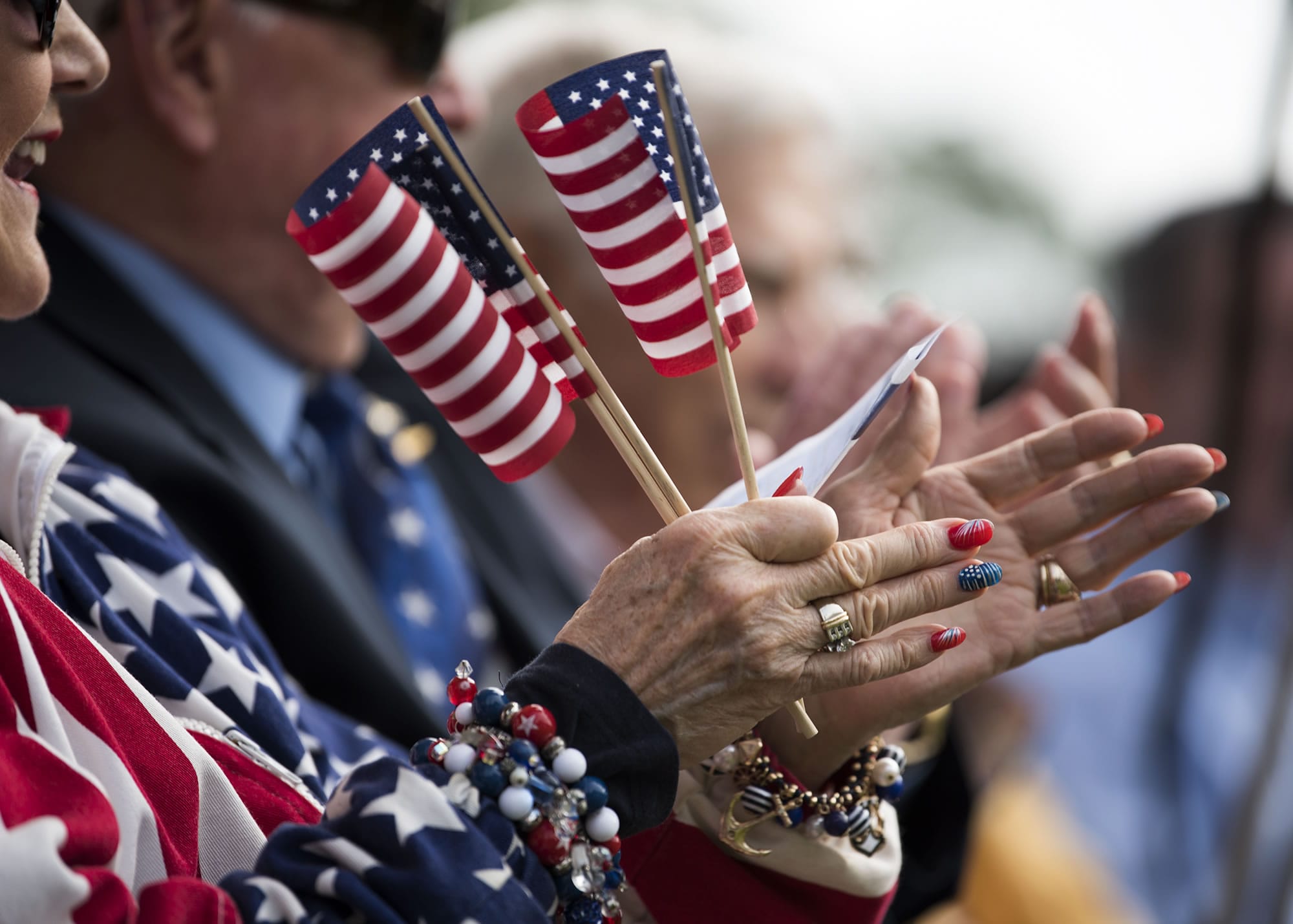 Judy Kutch of Washougal applauds during the Clark County mayors' patriotic tie contest at Fort Vancouver's 23rd annual Flag Day celebration on Wednesday June 14, 2017.