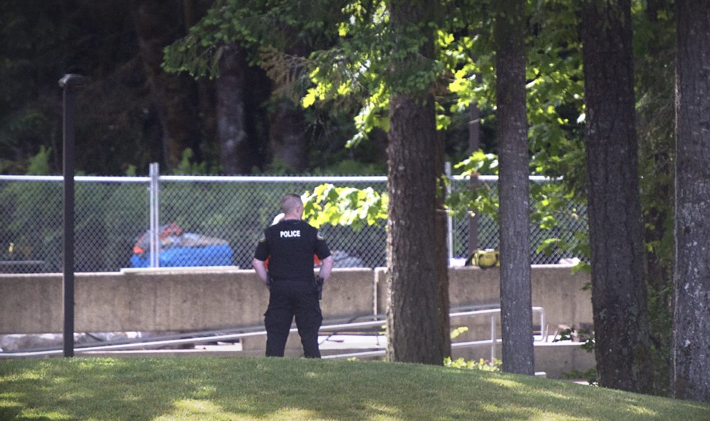 An Evergreen State College police officers keeps watch over campus as student evacuate following a "direct threat" on Thursday, June 1, 2017.  The announcement posted on the school's website Thursday asked everyone to leave the Olympia campus or return to residence halls for further instructions. The post did not provide other details.