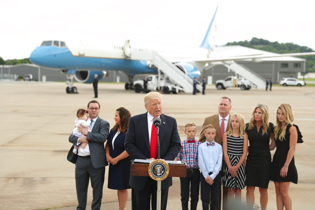 President Donald Trump speaks about healthcare at Cincinnati Municipal Lunken Airport in Cincinnati, Ohio, Wednesday, June 7, 2017.   Shown are PlayCare co-owner Rays Whalen, left, and CSS Distribution Group President Dan Withrow and their families.