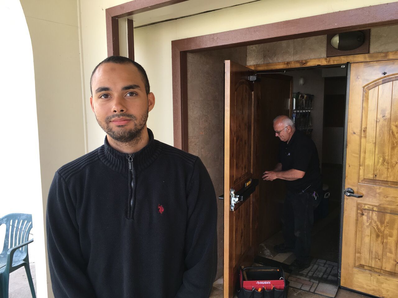 In this June 1, 2017, photo, Drew Williams, a member of the Eugene Islamic Center, poses for a portrait outside the building in Eugene, Ore., as locksmith Jim King upgrades the locks on the front doors. Williams said members of the mosque have been rattled by an incident in which a man showed up and allegedly threatened to kill worshippers, but that the community has shown concern and support.
