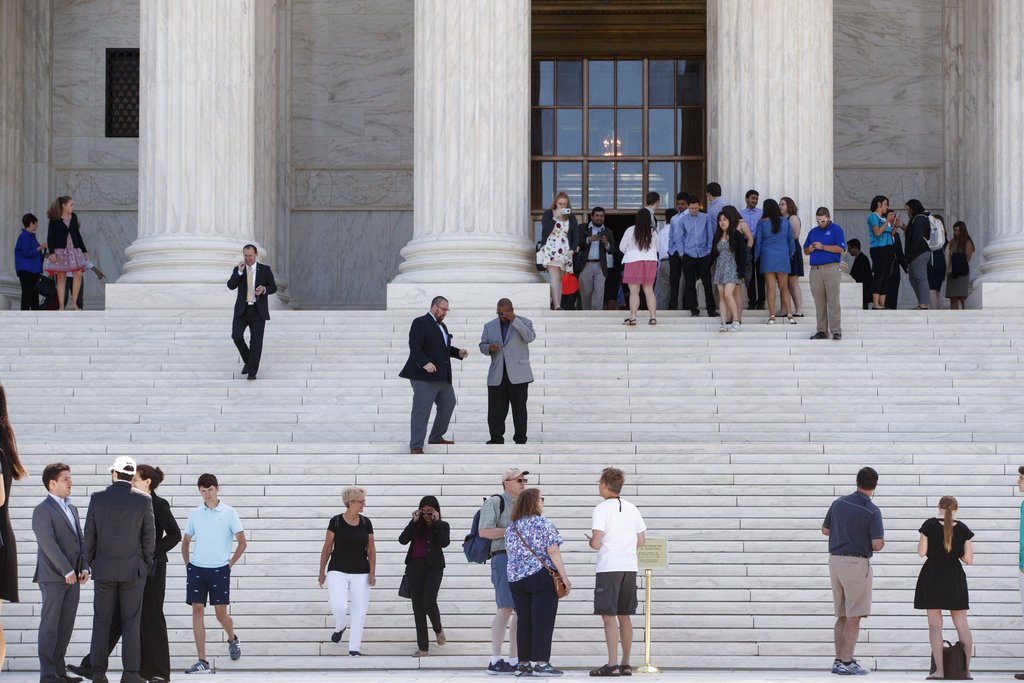 People leave the Supreme Court in Washington, Monday, June 26, 2017, as justices issued their final rulings for the term. The high court is letting a limited version of the Trump administration ban on travel from six mostly Muslim countries to take effect, a victory for President Donald Trump in the biggest legal controversy of his young presidency. (AP Photo/J.