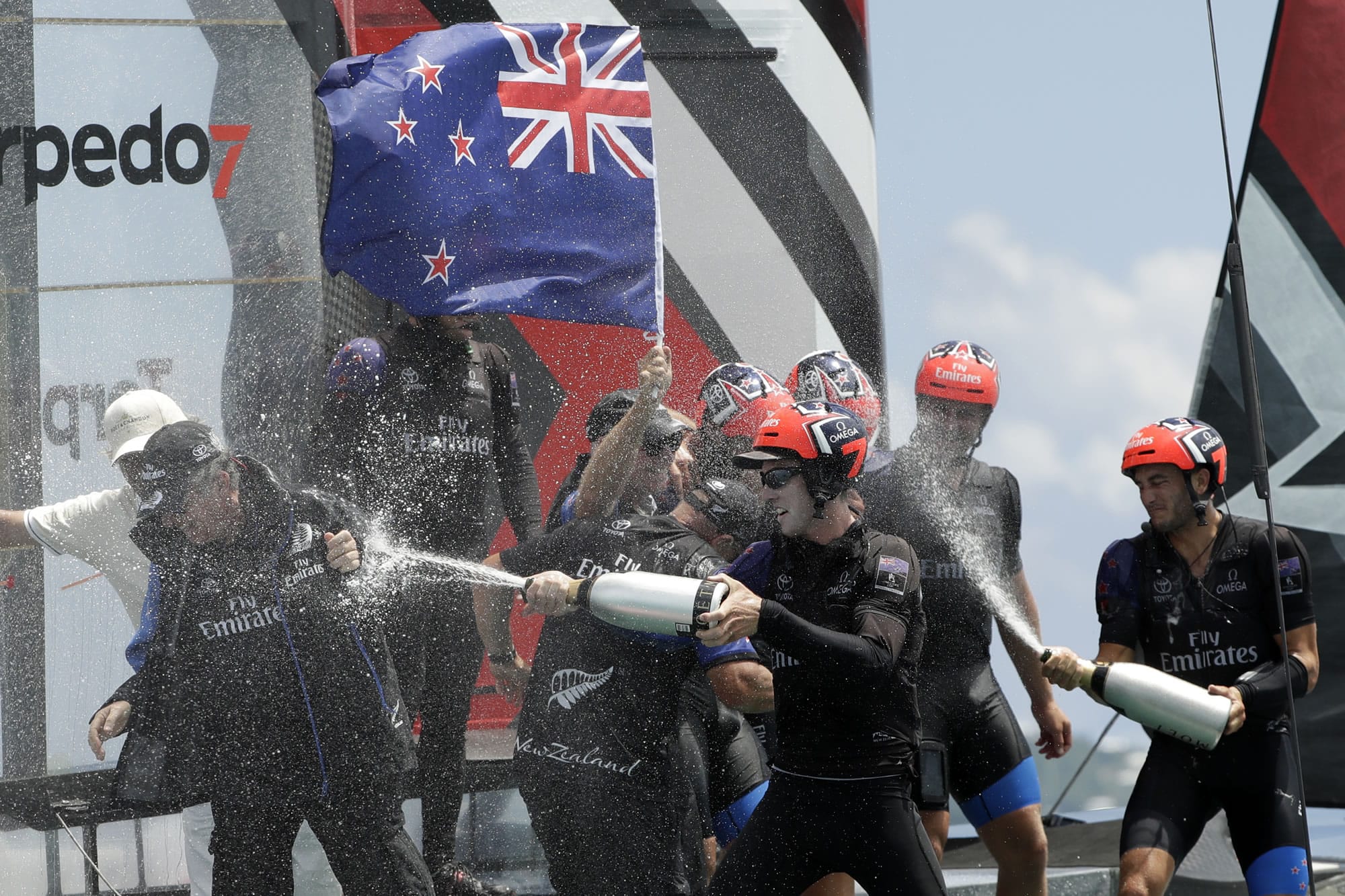 The crew of Emirates Team New Zealand spray champagne as they celebrate after defeating Oracle Team USA to win the America's Cup sailing competition Monday, June 26, 2017, in Hamilton, Bermuda.