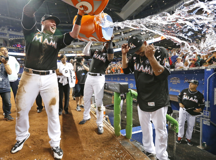 Miami Marlins’ Justin Bour, left, and Marcell Ozuna, center rear, pour ice and water onto starting pitcher Edinson Volquez, right, after he threw a no-hitter against the Arizona Diamondbacks Saturday in Miami.