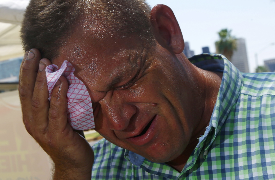 Steve Smith wipes sweat from his face Monday as temperatures climb to near-record highs in Phoenix. Ross D.