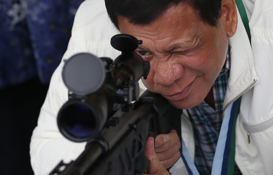Philippine President Rodrigo Duterte checks the scope of a Chinese-made CS/LR4A sniper rifle during the presentation of thousands of rifles and ammunition by China to the Philippines on Wednesday, at Clark Airbase in northern Philippines.