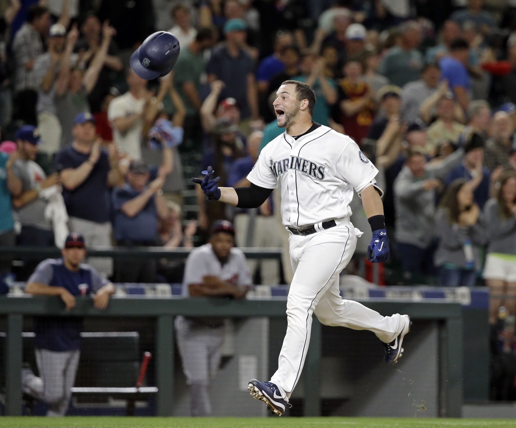 Seattle Mariners' Mike Zunino tosses his batting helmet as he heads home on his two-run home run, scoring the winning run against the Minnesota Twins in the ninth inning of a baseball game Wednesday, June 7, 2017, in Seattle. The Mariners won 6-5.