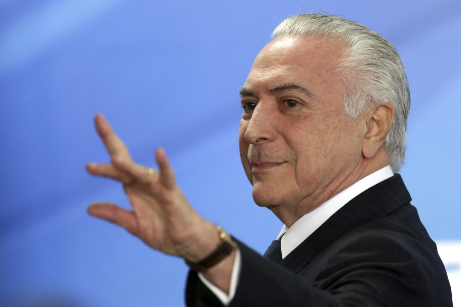 Brazil’s President Michel Temer waves as he exits after attending a ceremony at the Planalto Presidential Palace, in Brasilia, Monday, June 26, 2017. Temer is expressing defiance in the face of possible corruption charges, the lowest approval rating for a Brazilian leader in a generation and calls for his resignation. He says nothing will “destroy” his government.