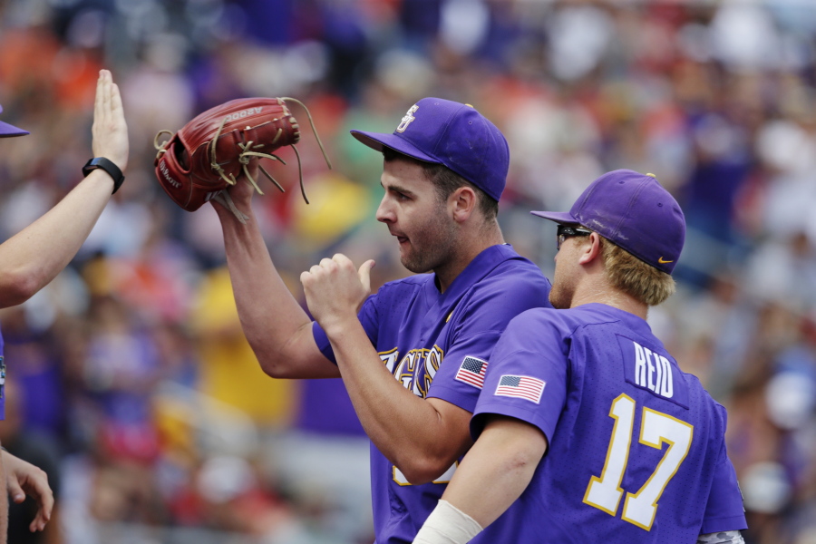 LSU pitcher Alex Lange celebrates with teammates as he leaves during the eighth inning of an NCAA College World Series baseball game against Oregon in Omaha, Neb., Friday, June 23, 2017.