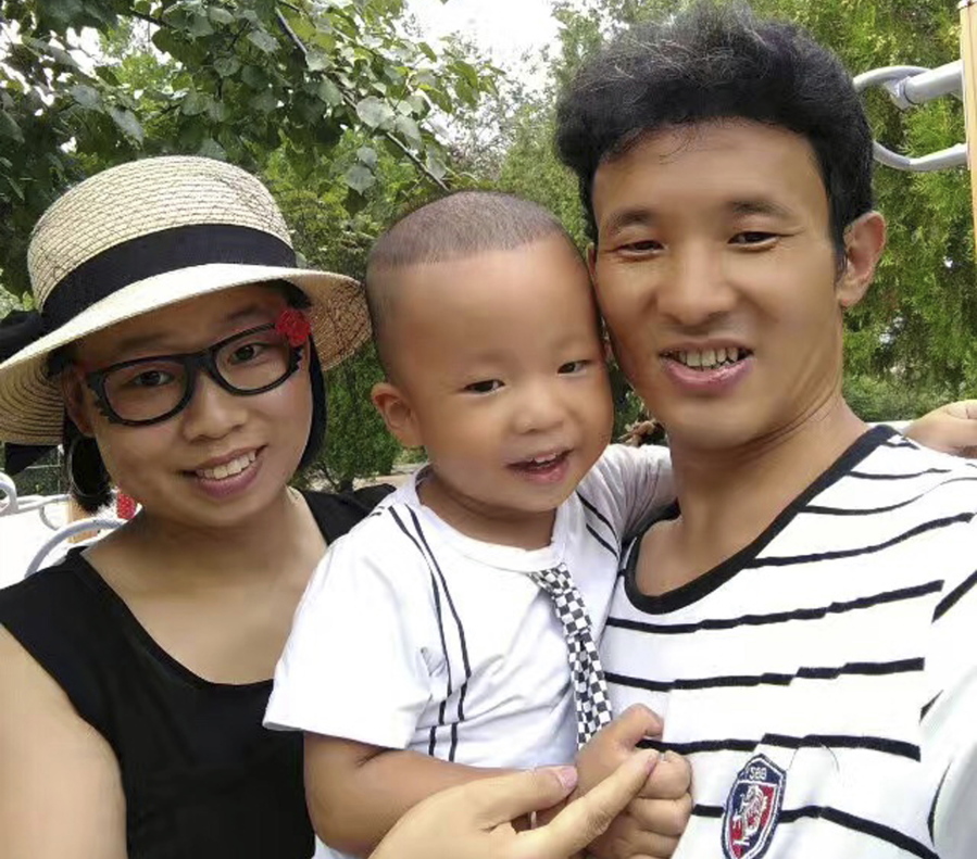 Deng Guilian, left, her husband, Hua Haifeng, right, and their son Bo Bo pose for a photo during a visit to a park in Chengde in northern China’s Hebei Province. Deng, 36, the wife of Hua an activist arrested while investigating labor conditions in Ivanka Trump’s supply chain has fallen into the ranks of similar families left with no source of income. Even beyond the financial suffering, the government has many ways of making life miserable for those left behind.