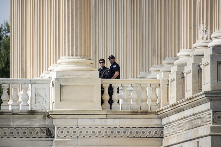Capitol Hill Police officers stand watch outside the House of Representatives on Capitol Hill in Washington on Thursday, a day after a gunman opened fire on a lawmakers playing baseball and wounded House Majority Whip Steve Scalise of La. at a baseball practice in Alexandria, Va. (AP Photo/J.