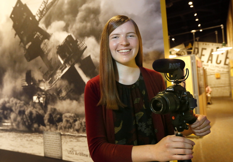 Hannah Doyle stands with her video recorder in the Hanford Reach National Monument’s section dedicated to stories of World War II veterans, merchant sailors, nurses, Manhattan Project workers and home front supporters in Richland.