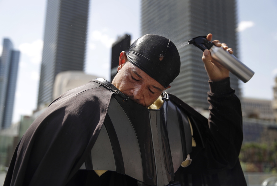 Chris Mitchell pours water over his head to cool off in a Darth Vader costume along the Las Vegas Strip, Tuesday, June 20, 2017, in Las Vegas. Mitchell was taking a break from posing for photographs with tourists. The first day of summer is forecast to bring some of the worst heat the southwestern U.S. has seen in years.