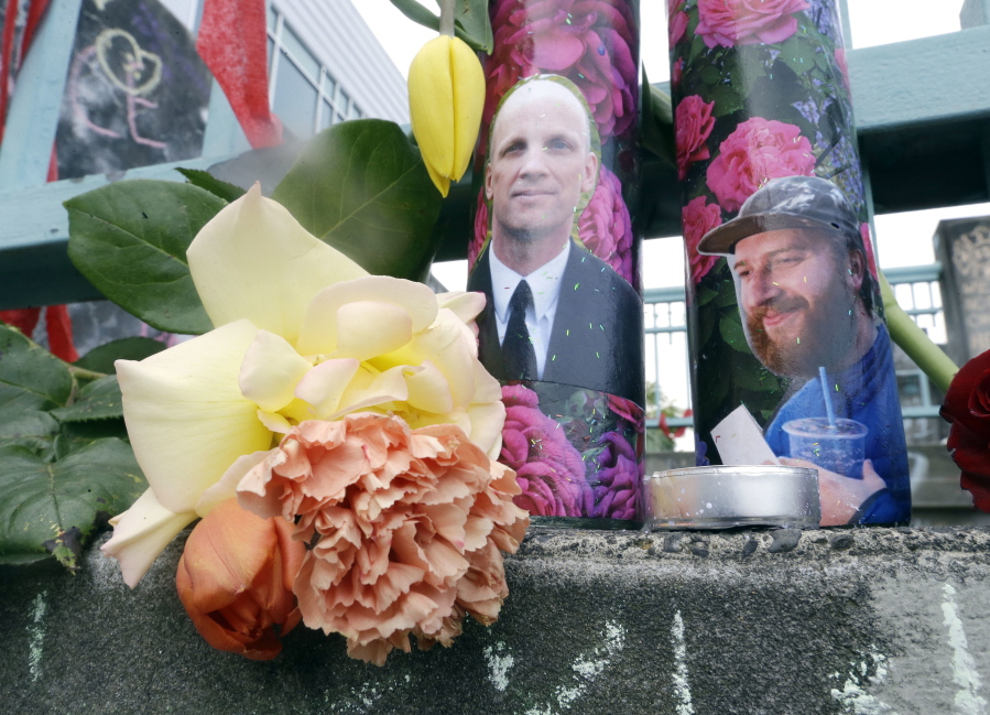 Candles with photos of Taliesin Namkai-Meche, right, and Ricky Best on them are shown at a memorial for the two men in Portland, Ore., Wednesday, May 31, 2017, The man charged with fatally stabbing the two men and injuring a third who tried to shield young women from an anti-Muslim tirade, appeared to brag about the attacks as he sat in the back of a police patrol car according to court documents.(AP Photo/Don Ryan)