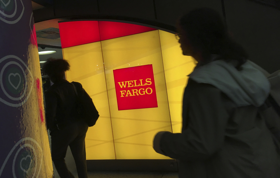 FILE - In this Thursday, Oct. 13, 2016, file photo, commuters walk by a Wells Fargo ATM location at New York's Penn Station. On Wednesday, June 28, 2017, the Federal Reserve gave the green light to all 34 of the biggest banks in the U.S. to raise their dividends and buy back shares, judging their financial foundations sturdy enough to withstand a major economic downturn. Those allowed to raise dividends or repurchase shares include the four biggest U.S. banks: JPMorgan Chase, Bank of America, Citigroup and Wells Fargo. (AP Photo/Swayne B.