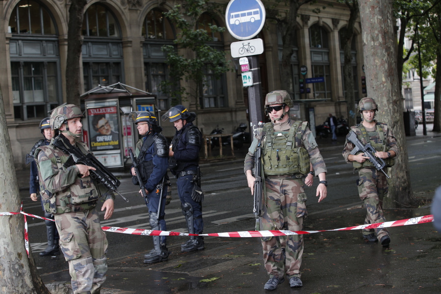 Police officers and soldiers seal off the access to Notre Dame cathedral after a man attacked officers with a hammer while patrolling the esplanade in front of the famous landmark, in Paris, France, on Tuesday. Paris prosecutors have opened a counterterrorism investigation after an unidentified assailant attacked police with a hammer outside Notre Dame Cathedral.