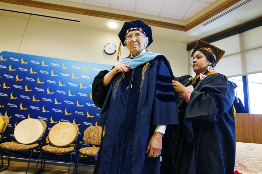 Elese Washines, assistant professor at Heritage University performs a hooding ceremony Monday honoring Russell Jim, manager of the Yakama Nation’s Environmental Restoration and Environmental Cleanup program at Heritage University in Toppenish.