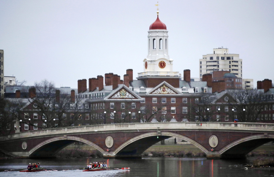 Rowers paddle along the Charles River past the Harvard College campus in Cambridge, Mass. The Harvard Crimson, the school’s student newspaper, reported Sunday that Harvard revoked admission offers to at least 10 prospective freshmen over offensive online messages.
